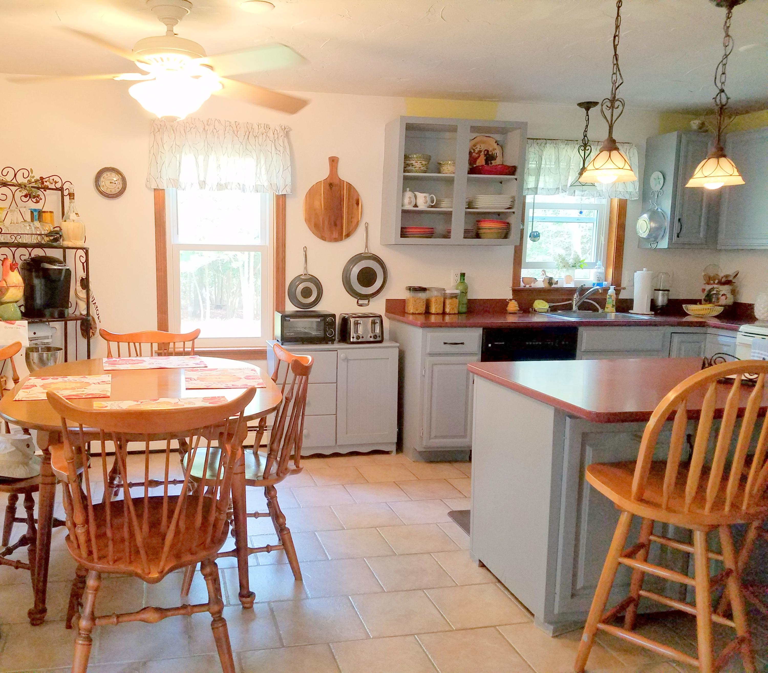 835 Cotuit Road Mashpee, MA 02649 - Photo 8 of 14 a kitchen with kitchen island a dining table chairs and a sink