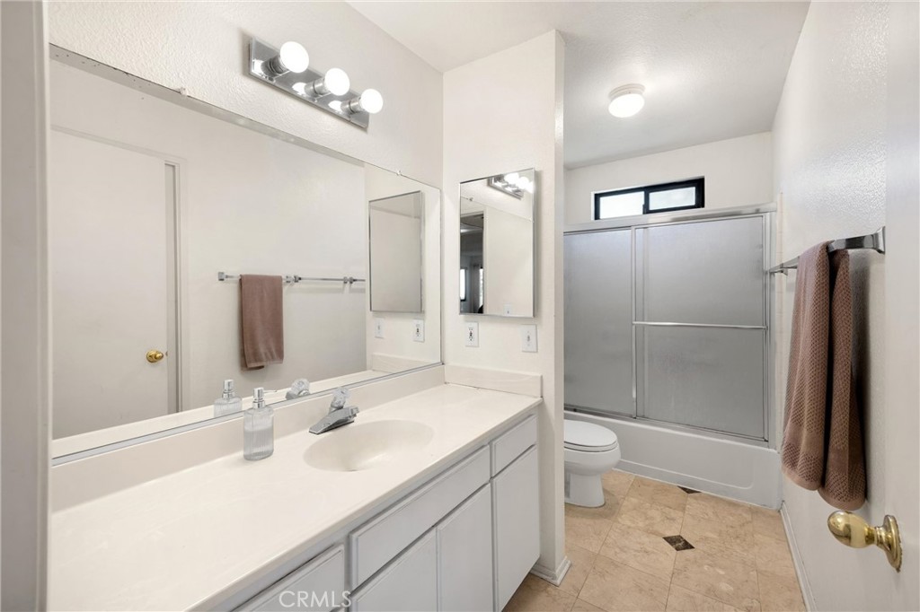 8333 Vineyard Avenue, Unit 4 Rancho Cucamonga, CA 91730 - Photo 14 of 22 a bathroom with a double vanity sink toilet mirror and shower