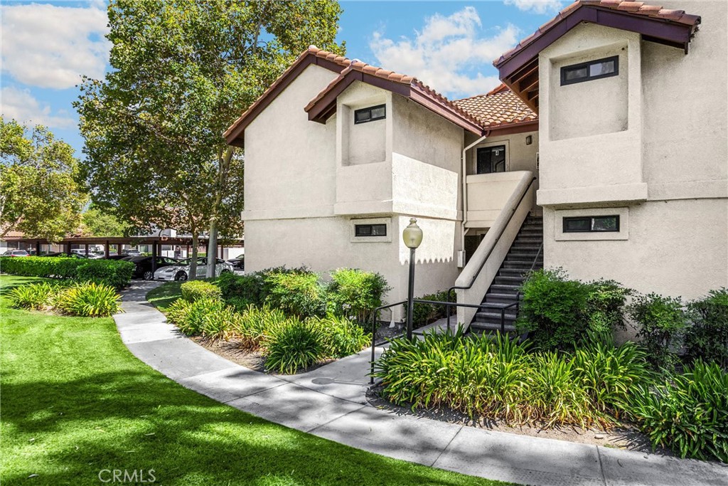 8333 Vineyard Avenue, Unit 4 Rancho Cucamonga, CA 91730 - Photo 18 of 22 a white building with a big yard and potted plants in front of door