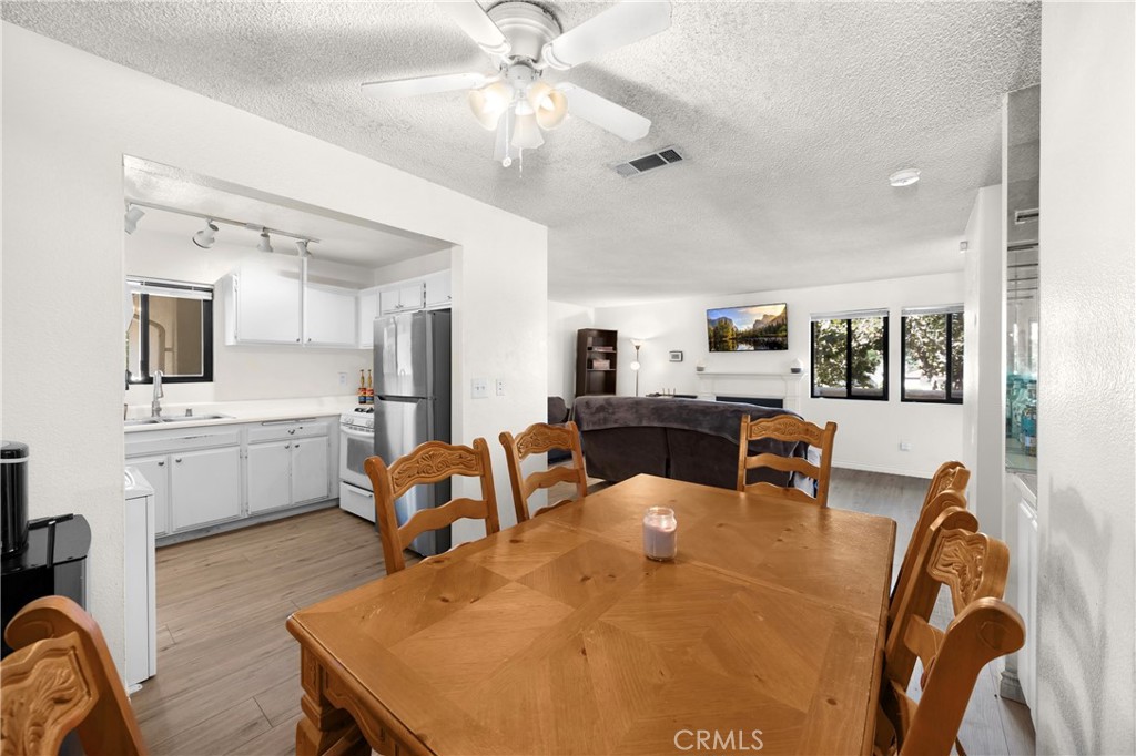 8333 Vineyard Avenue, Unit 4 Rancho Cucamonga, CA 91730 - Photo 4 of 22 a living room with furniture a chandelier fan and a kitchen view