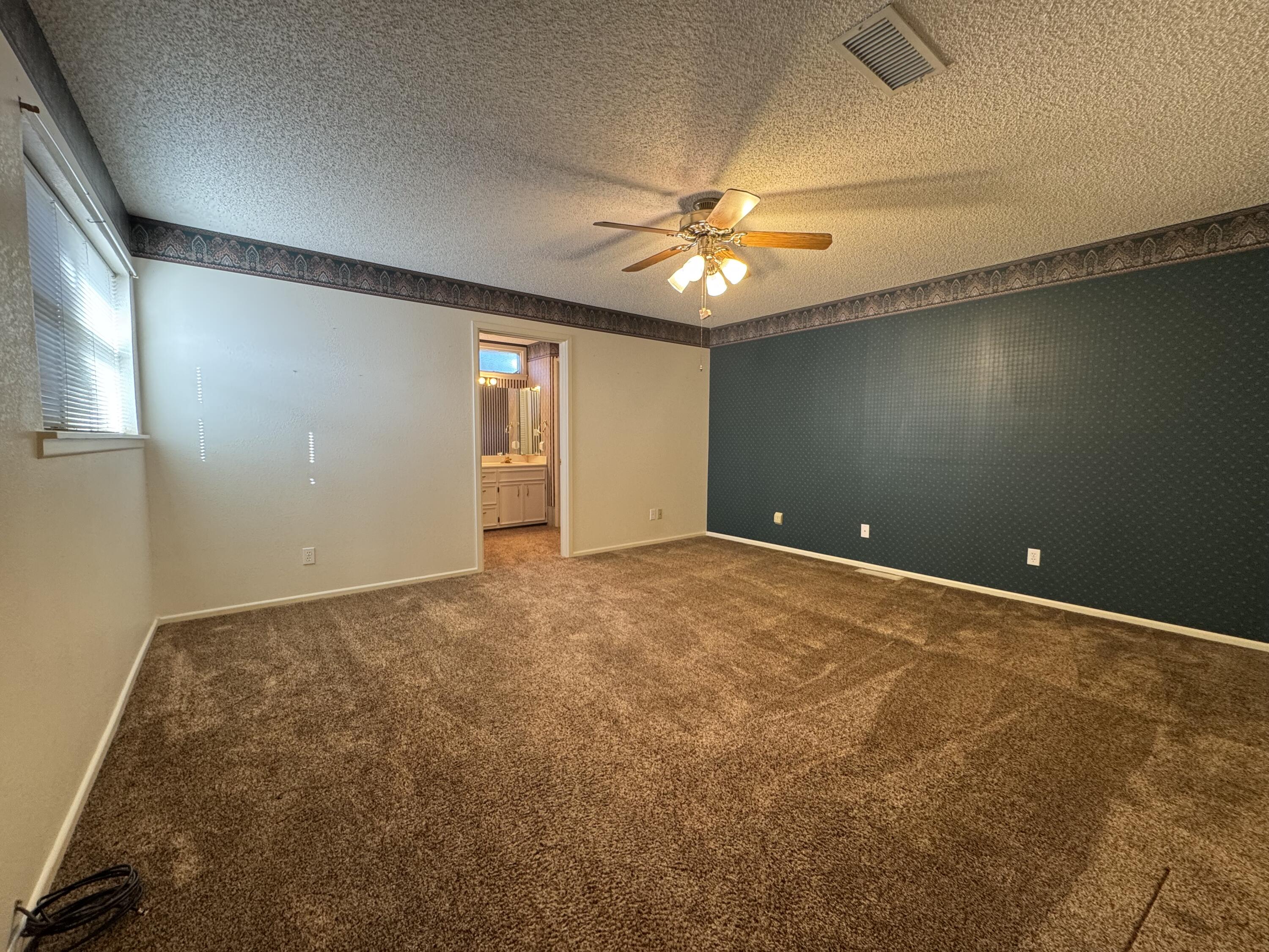 2208 South 4th Street Lamesa, TX 79331 - Photo 16 of 36 an empty room with a ceiling fan and carpet