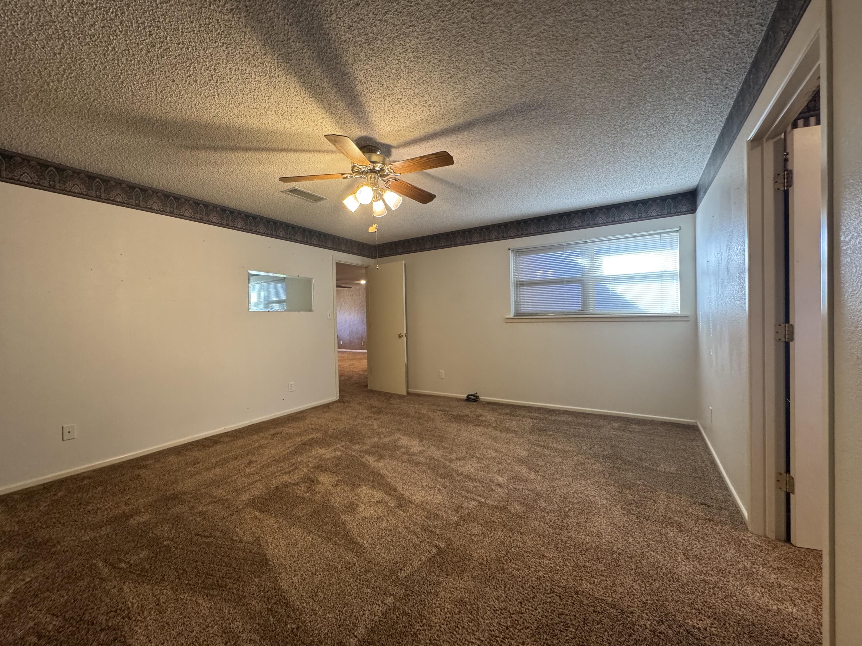 2208 South 4th Street Lamesa, TX 79331 - Photo 17 of 36 an empty room with windows and fan