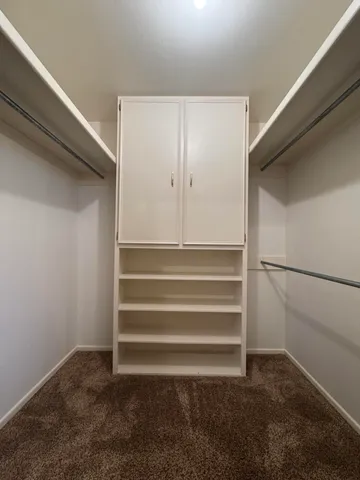 a view of walk in closet with empty racks