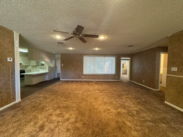 a view of an empty room with window and cabinet
