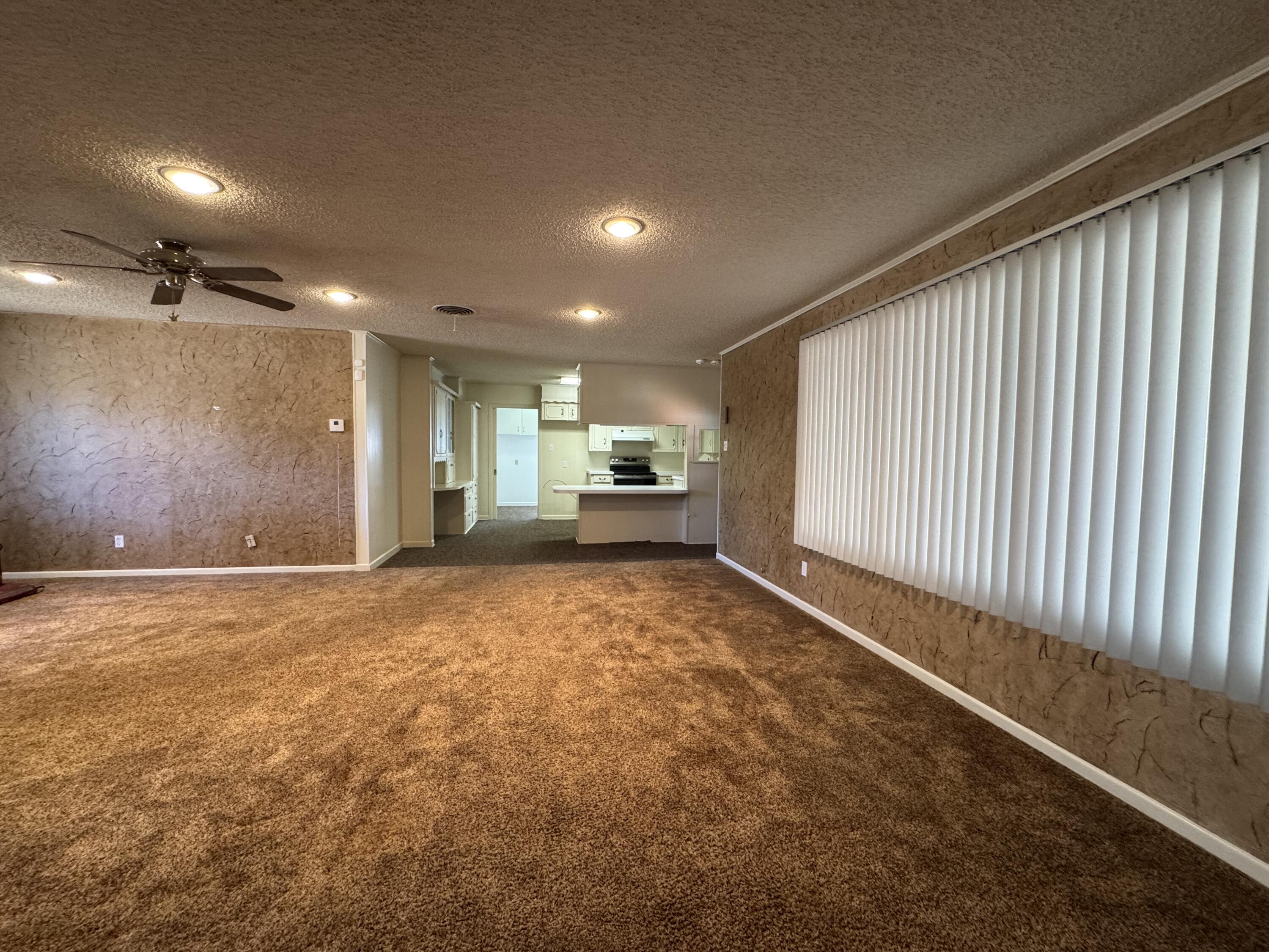 2208 South 4th Street Lamesa, TX 79331 - Photo 6 of 36 a view of an empty room with furniture and a kitchen