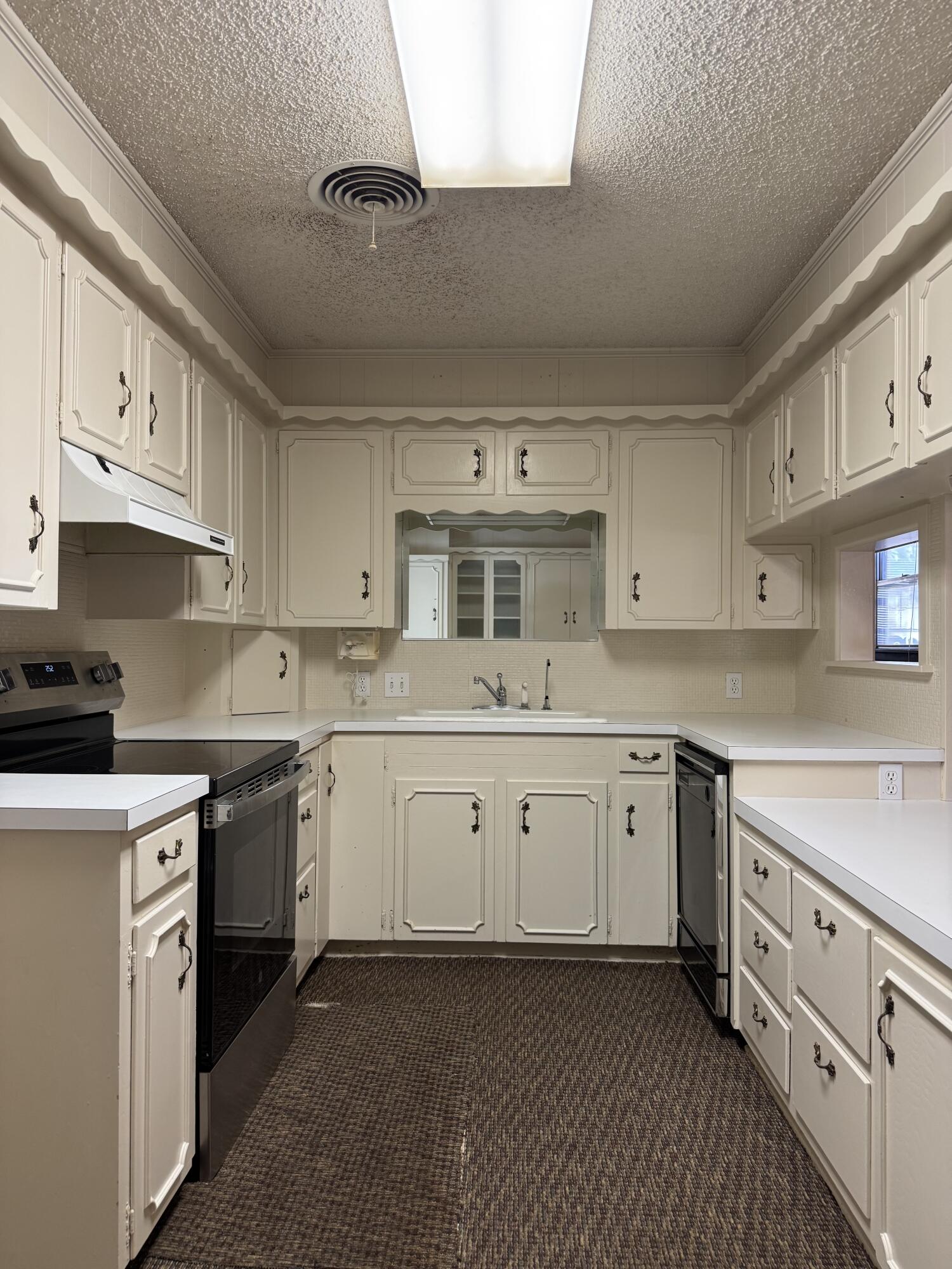 2208 South 4th Street Lamesa, TX 79331 - Photo 8 of 36 a kitchen with cabinets stainless steel appliances a sink and a counter top space