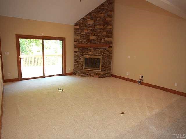 10005 Grafton Road Raleigh, NC 27615 - Photo 6 of 25 Great room with majestic stone fireplace, doors to deck , new carpet and vaulted ceiling!