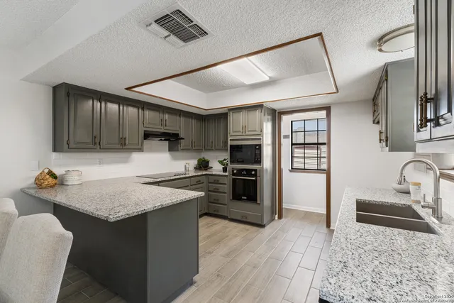 a kitchen with stainless steel appliances granite countertop a sink stove and refrigerator