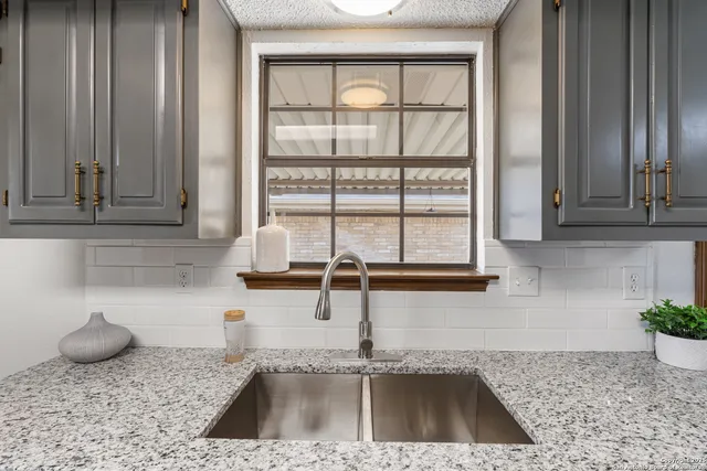 a kitchen with granite countertop a sink and a stove
