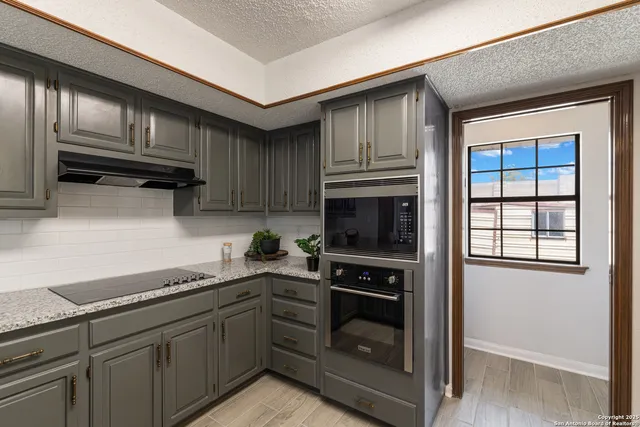 a kitchen with granite countertop a stove top oven cabinetry a sink and dishwasher