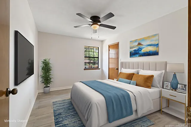 a bedroom with a large bed and a chandelier