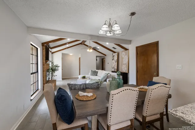 a view of a dining room with furniture and chandelier