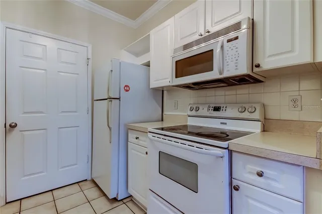 a kitchen with stainless steel appliances granite countertop white cabinets and a stove top oven