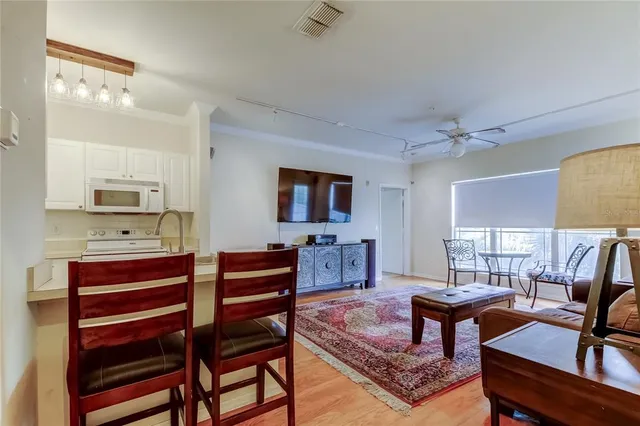 a living room with furniture a flat screen tv and kitchen view