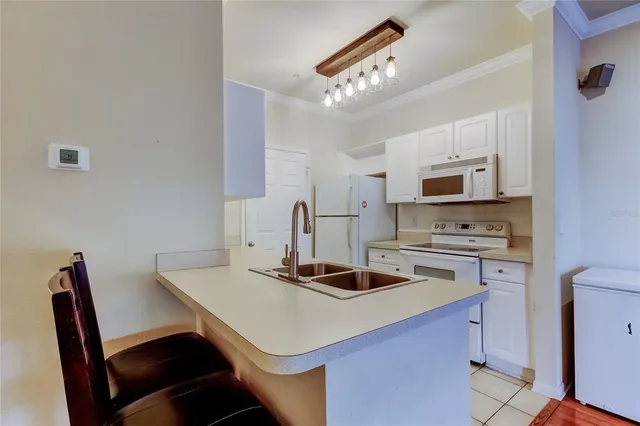 a kitchen with a appliances a table and chairs in it