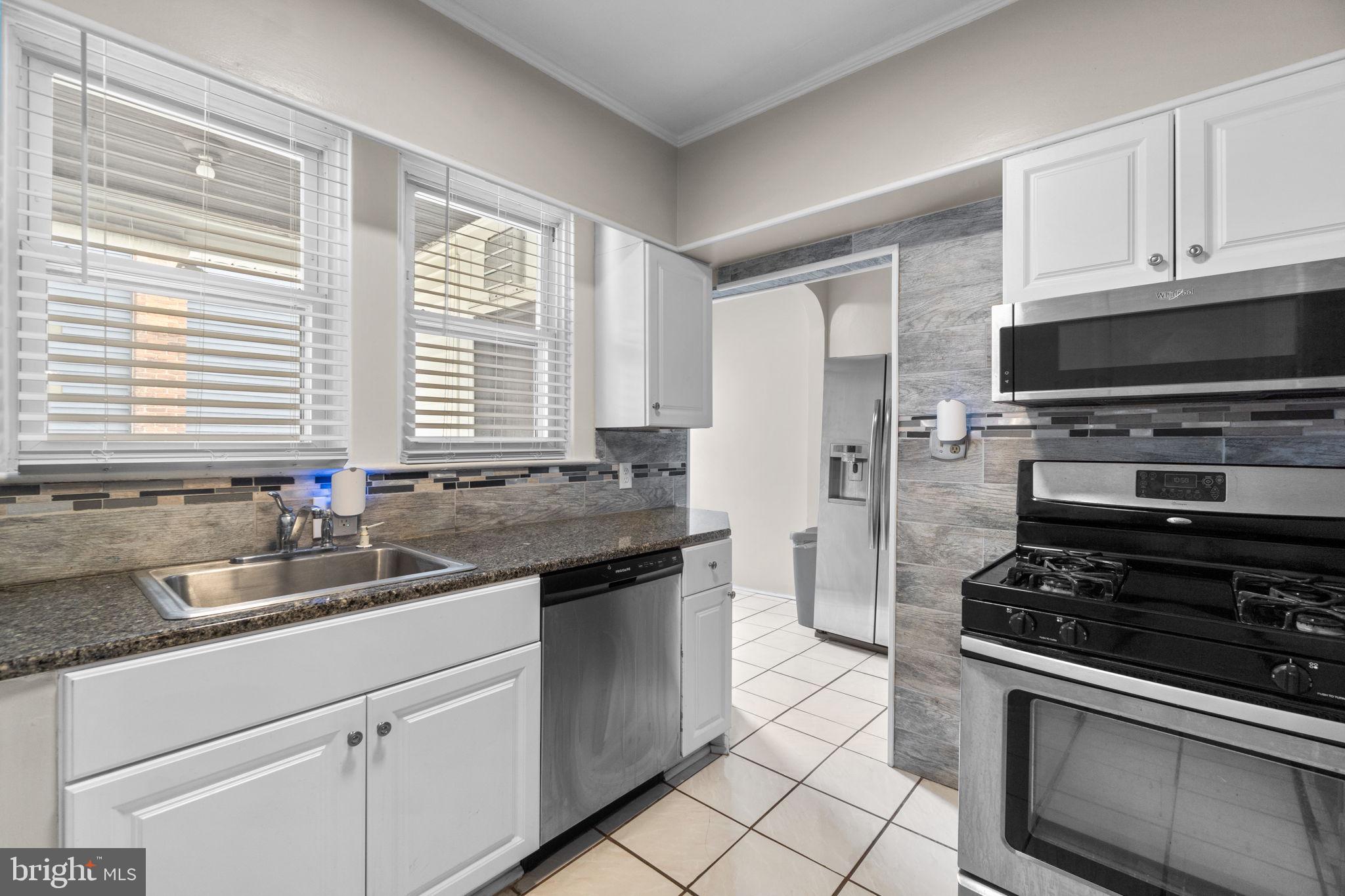 4213 Springdale Avenue Baltimore, MD 21207 - Photo 11 of 41 a kitchen with stainless steel appliances a stove sink and microwave