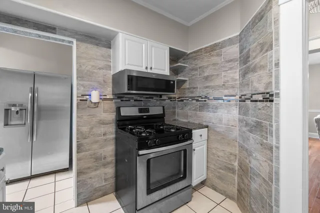 a kitchen with stainless steel appliances granite countertop a stove a refrigerator and a microwave