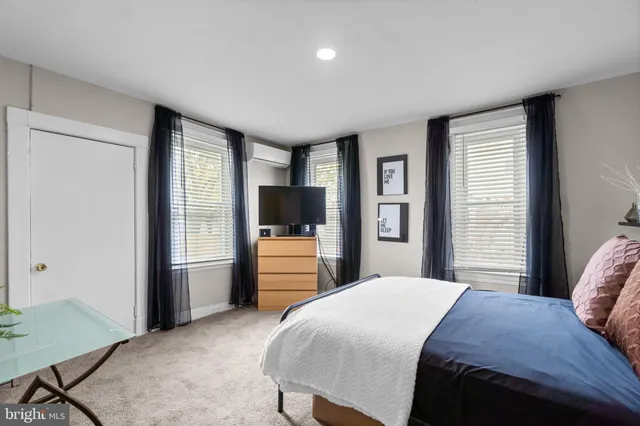 a bedroom with a large bed and a flat tv screen