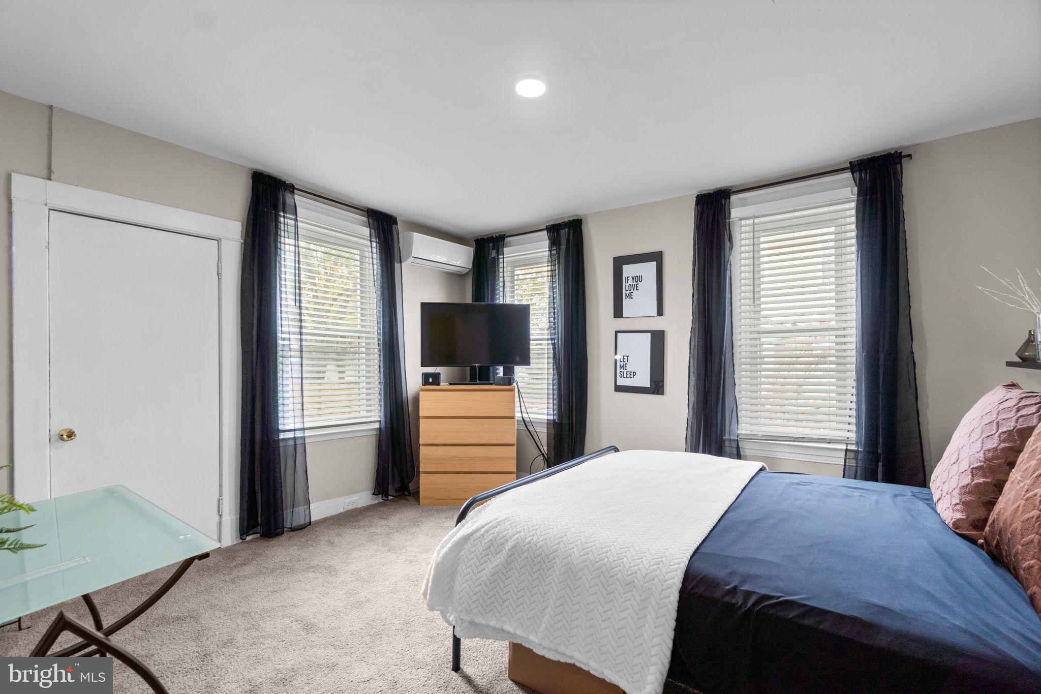 4213 Springdale Avenue Baltimore, MD 21207 - Photo 15 of 41 a bedroom with a large bed and a flat tv screen