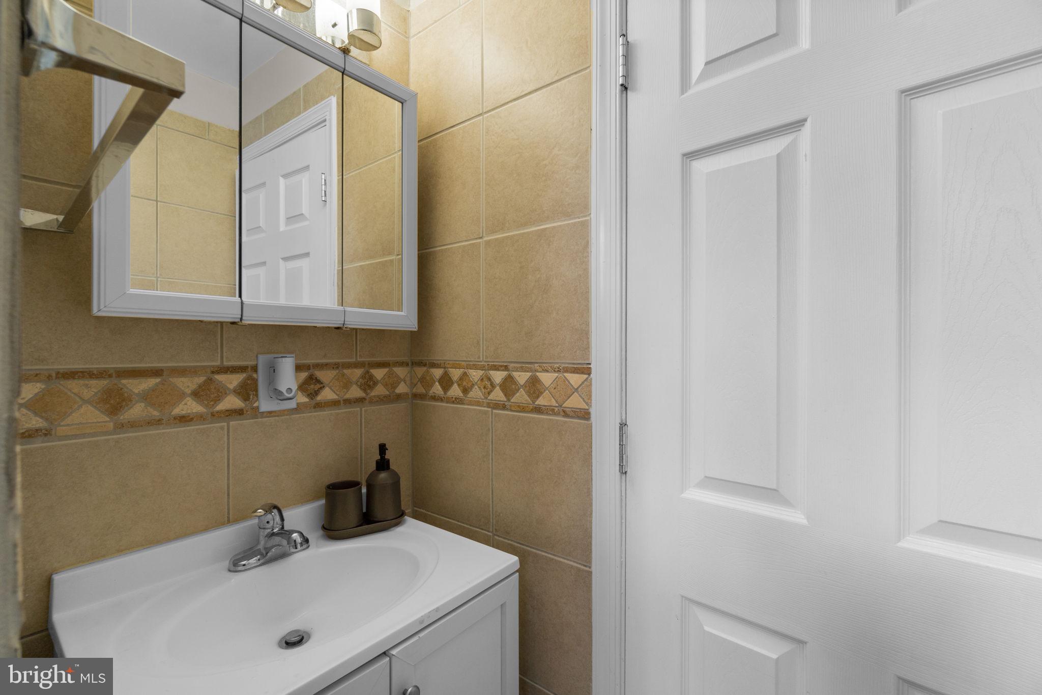 4213 Springdale Avenue Baltimore, MD 21207 - Photo 17 of 41 a bathroom with a sink and a mirror