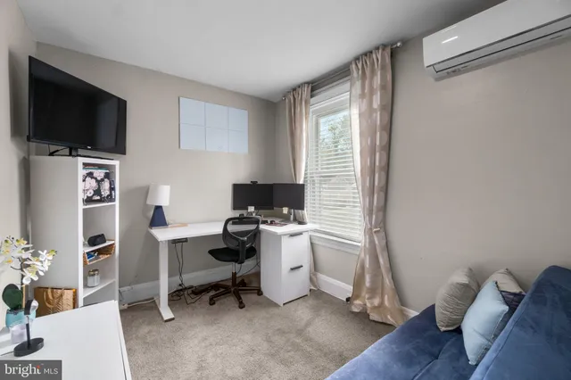 a view of a workspace with furniture and a flat screen tv