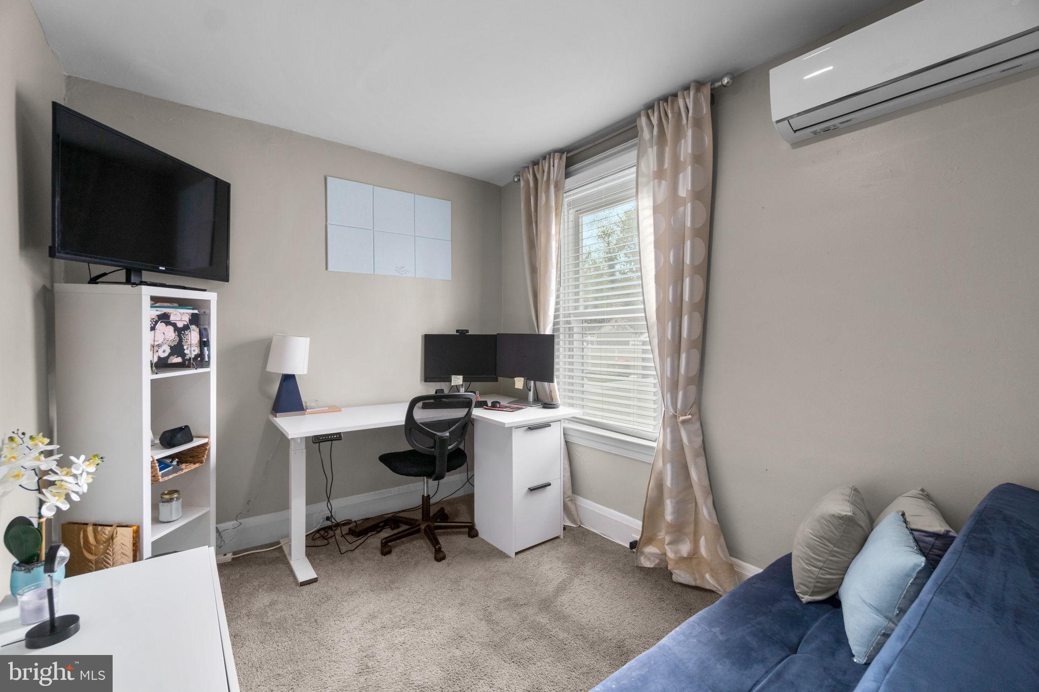 4213 Springdale Avenue Baltimore, MD 21207 - Photo 19 of 41 a view of a workspace with furniture and a flat screen tv