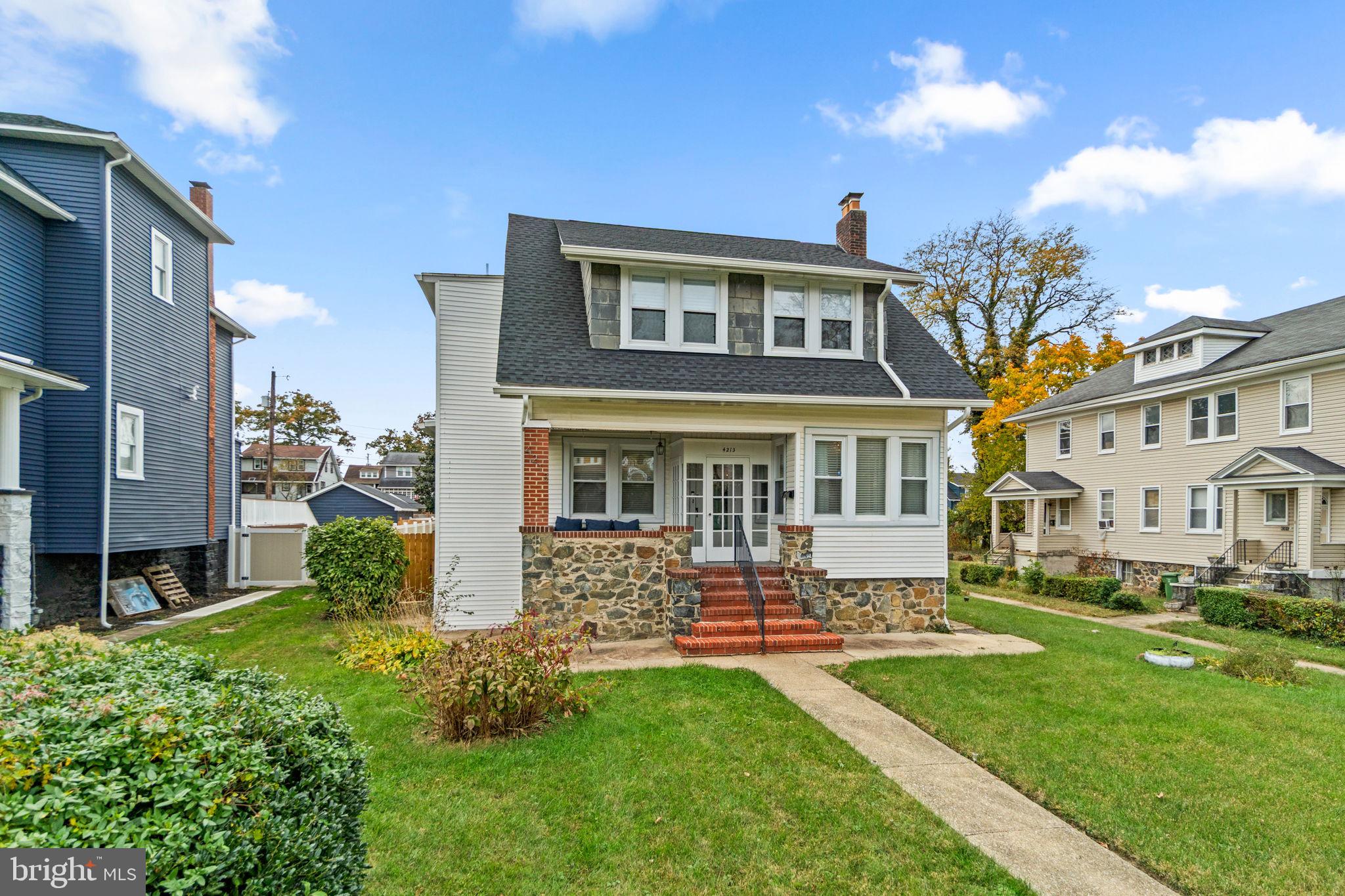 4213 Springdale Avenue Baltimore, MD 21207 - Photo 2 of 41 a front view of a house with a yard table and chairs