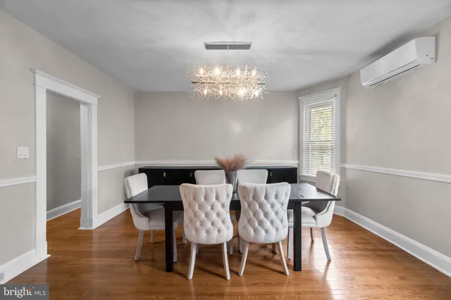 a view of a dining room with furniture a chandelier and wooden floor