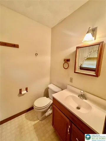 a bathroom with a sink mirror vanity and toilet