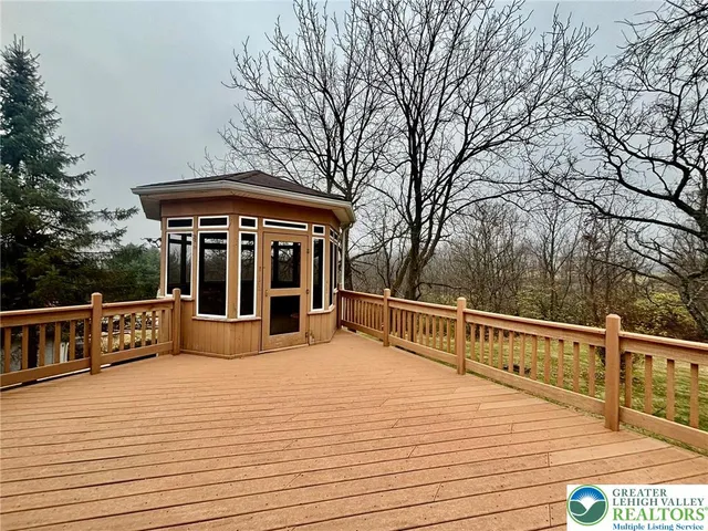 a view of house with deck outdoor seating and covered with wooden fence