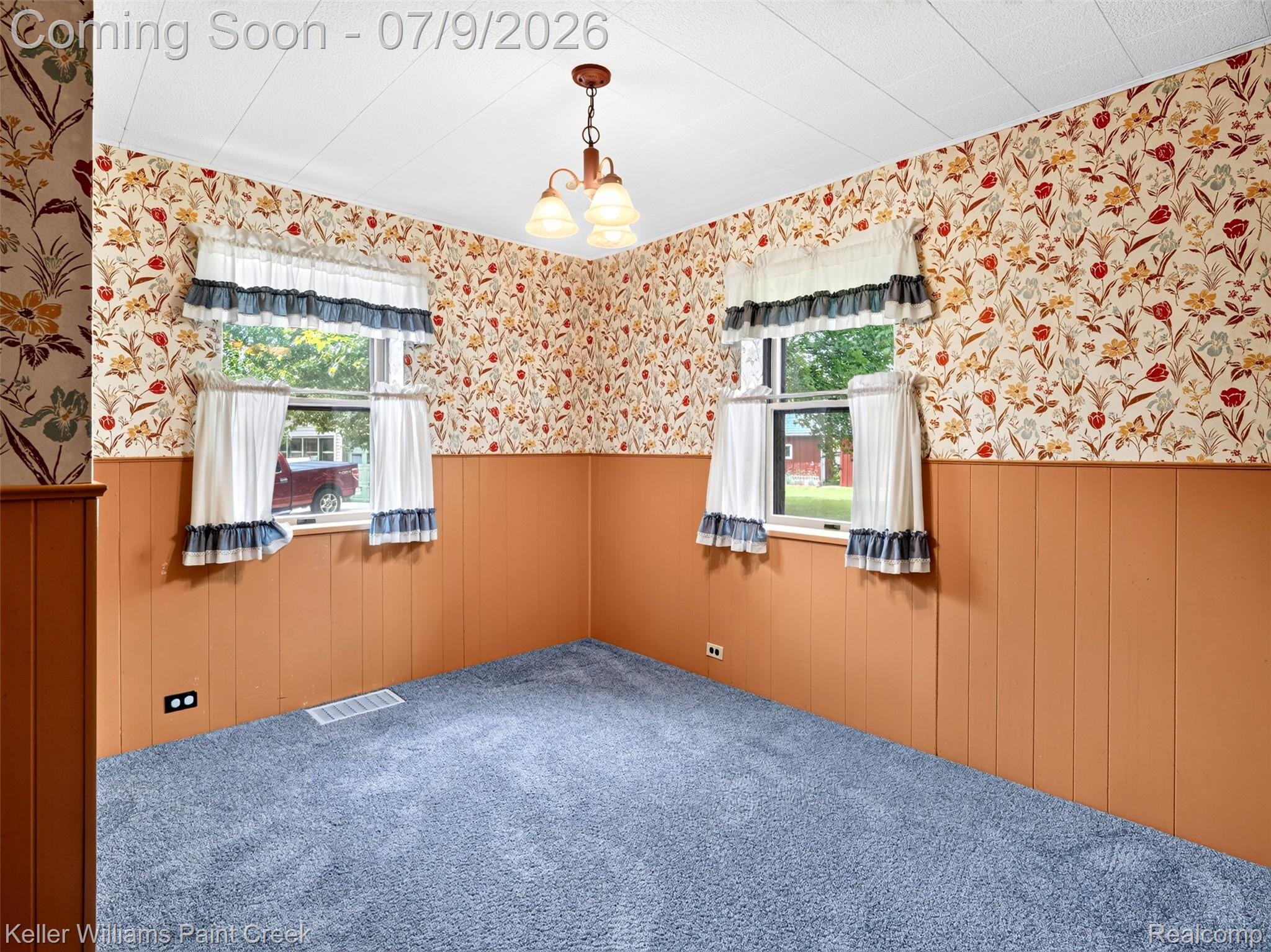 204 Russell Road Kawkawlin, MI 48631 - Photo 35 of 82 Room featuring blue carpeting, two windows, and a ceiling-mounted light fixture