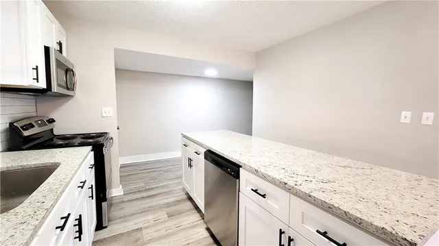 a kitchen with granite countertop wooden cabinets and a stove