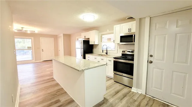a kitchen with a sink a stove and cabinets