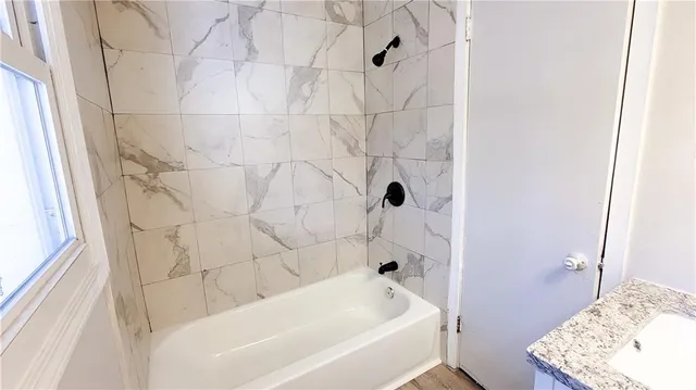 a bathroom with a bathtub and shower