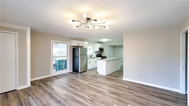 a view of a kitchen with wooden floor and a refrigerator