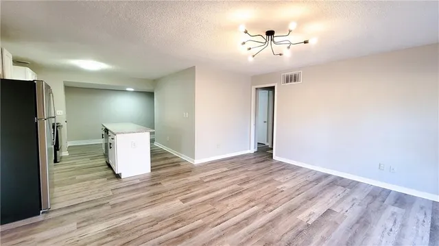 a view of a kitchen with wooden floor and a ceiling fan