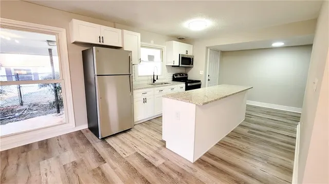 a kitchen with white cabinets and refrigerator