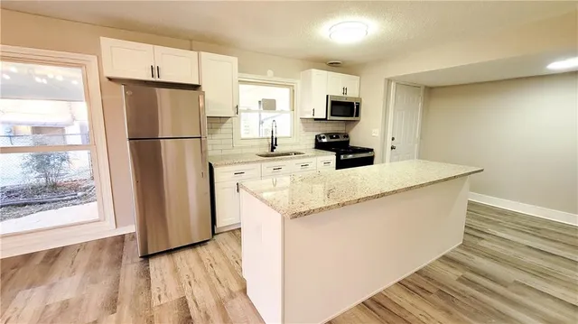 a kitchen with stainless steel appliances a refrigerator sink and microwave