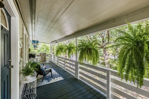 a view of a balcony with chairs and a potted plant