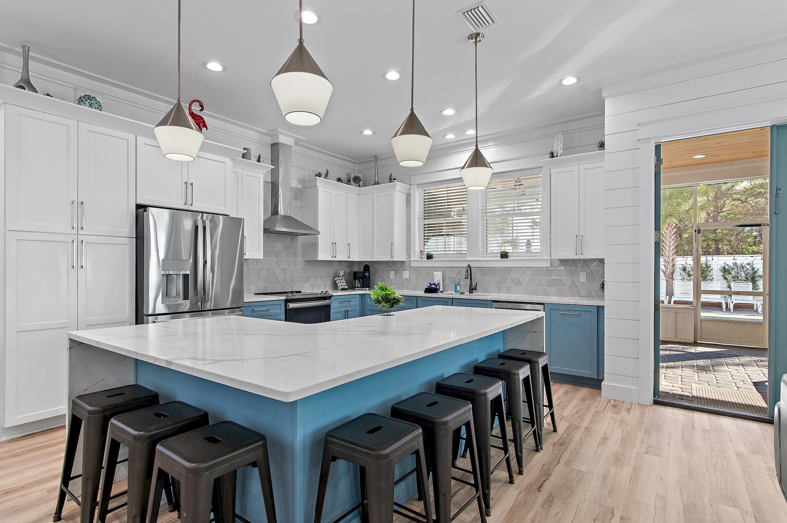 57 Penelope Street Miramar Beach, FL 32550 - Photo 20 of 62 a kitchen with granite countertop a table chairs stainless steel appliances and wooden floor