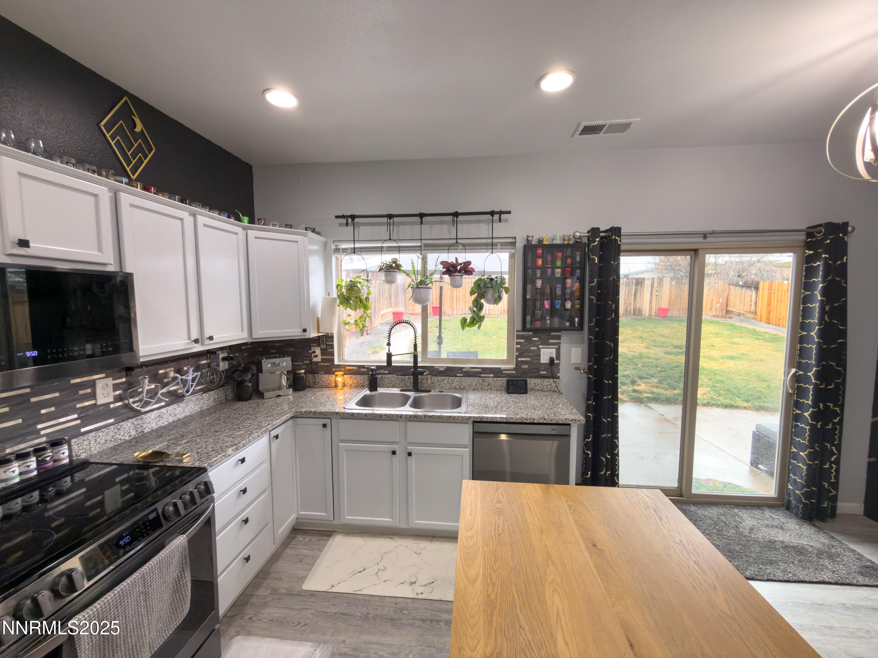 9635 Meadowstar Drive Reno, NV 89506 - Photo 11 of 26 a kitchen with stainless steel appliances a sink stove and cabinets