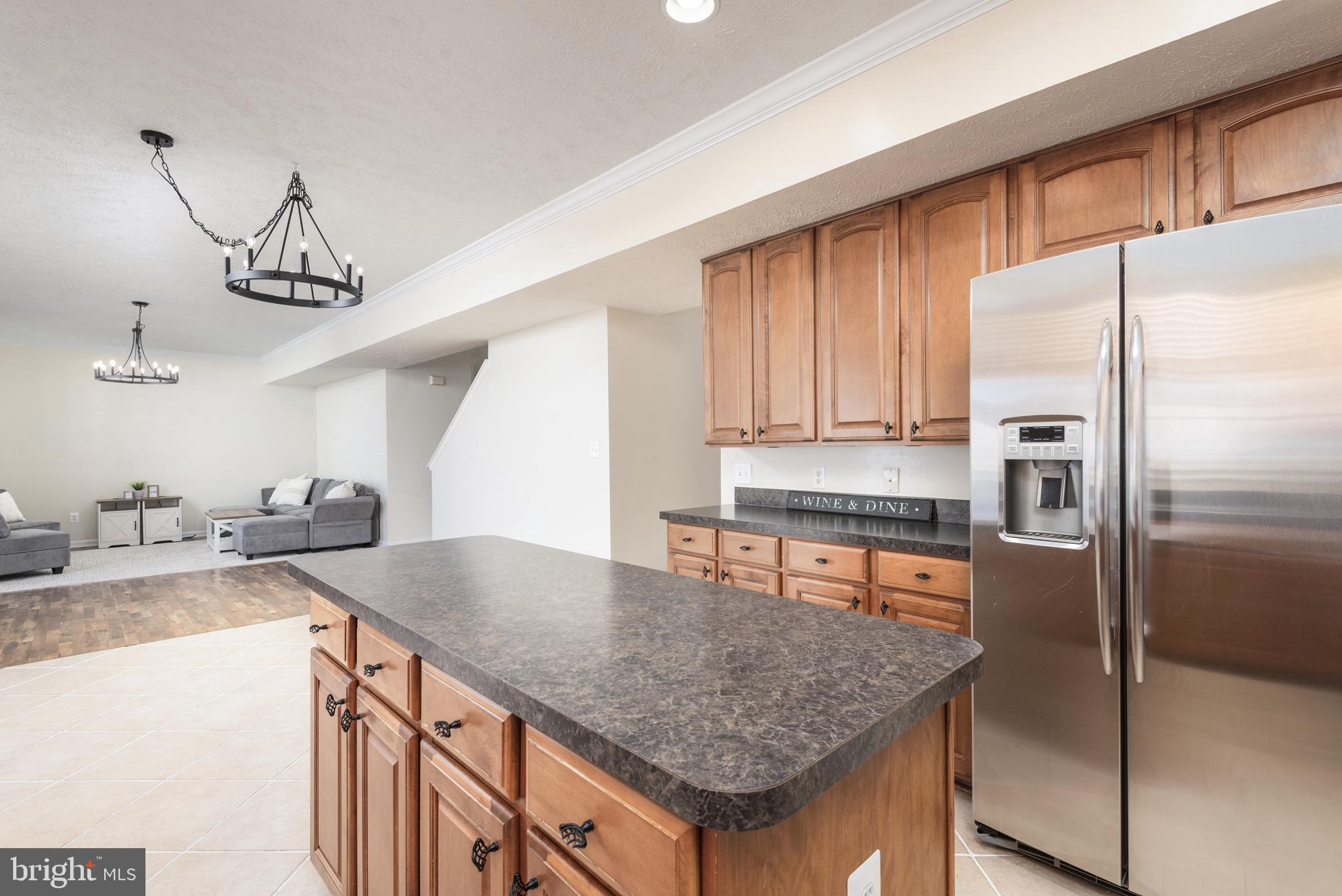 1208 Painted Fern Road Denton, MD 21629 - Photo 13 of 39 a kitchen with stainless steel appliances granite countertop a sink a refrigerator and a wooden floor