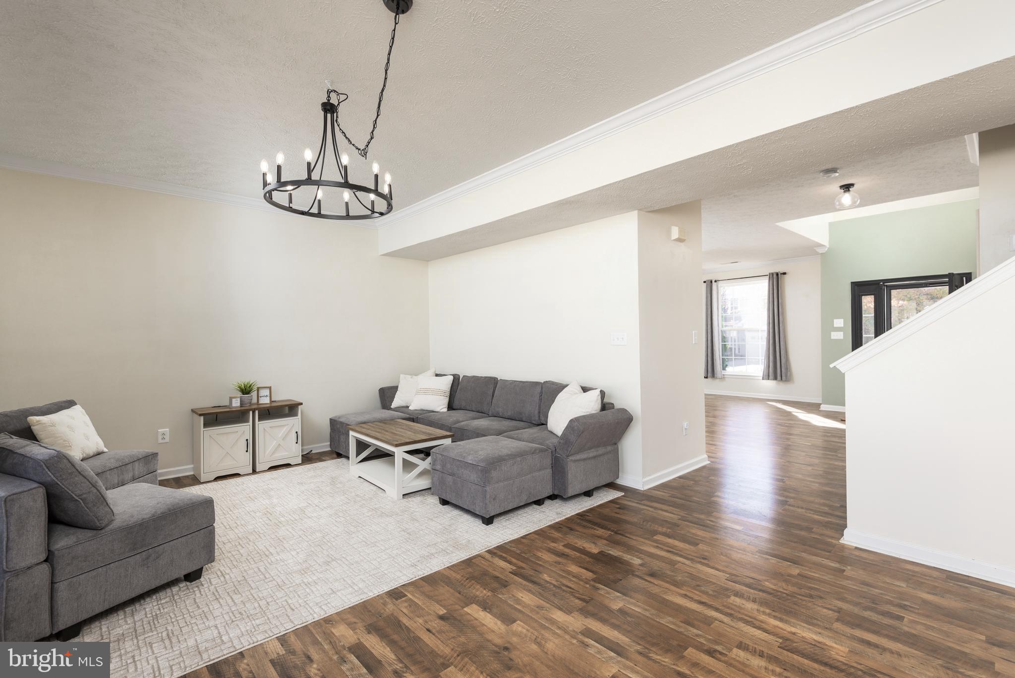 1208 Painted Fern Road Denton, MD 21629 - Photo 14 of 39 a living room with couches and kitchen view with wooden floor