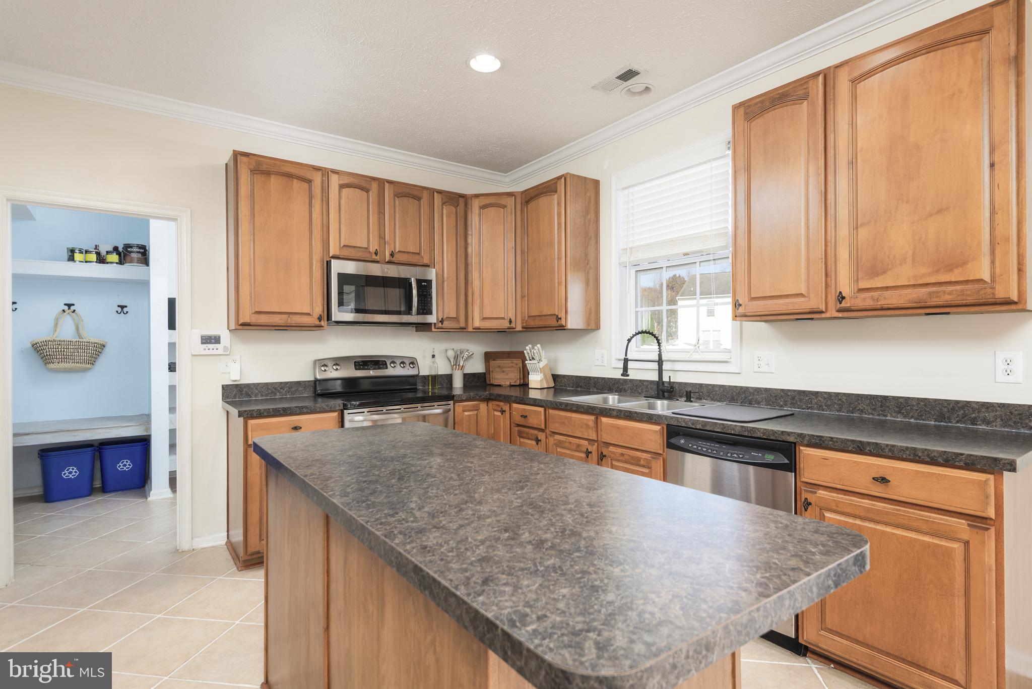 1208 Painted Fern Road Denton, MD 21629 - Photo 16 of 39 a kitchen with granite countertop a stove top oven a sink dishwasher and cabinets with wooden floor