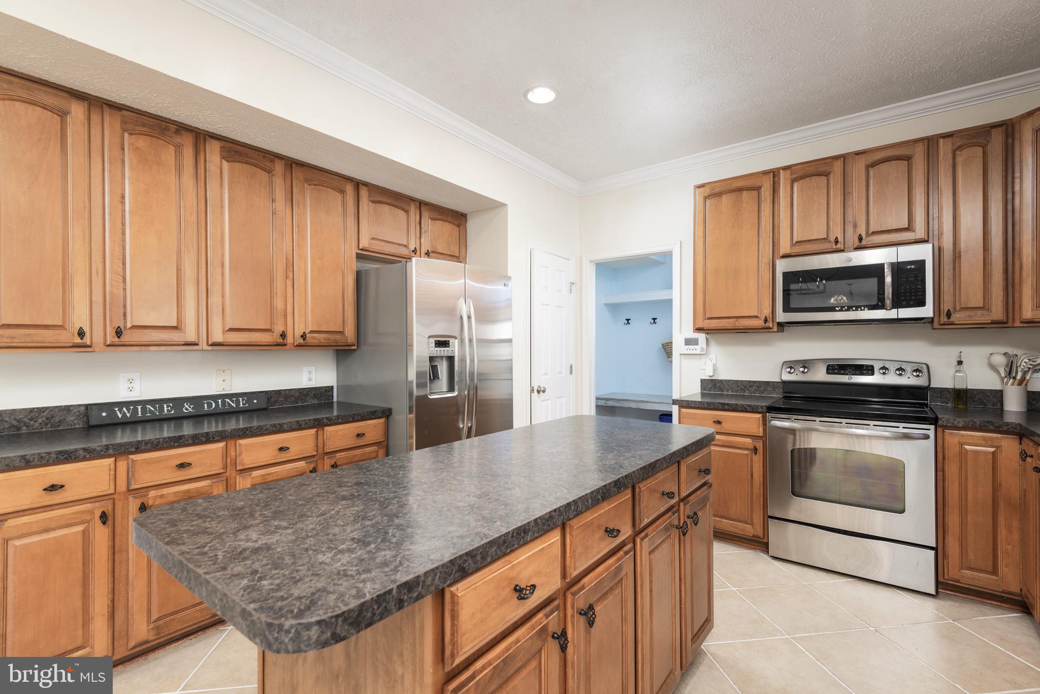 1208 Painted Fern Road Denton, MD 21629 - Photo 17 of 39 a kitchen with stainless steel appliances granite countertop a stove a sink and a microwave