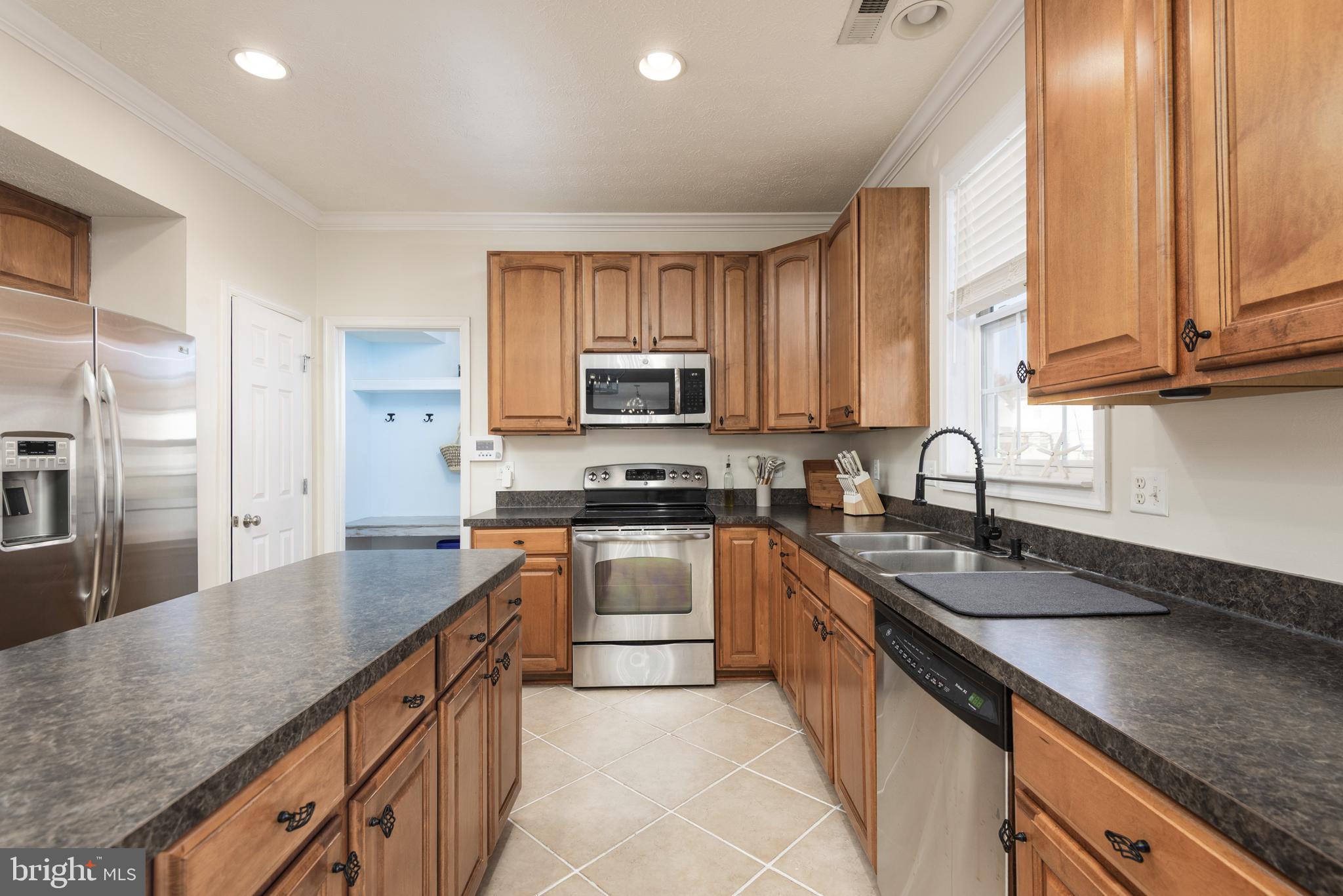 1208 Painted Fern Road Denton, MD 21629 - Photo 18 of 39 a kitchen with stainless steel appliances granite countertop a sink a stove and a refrigerator