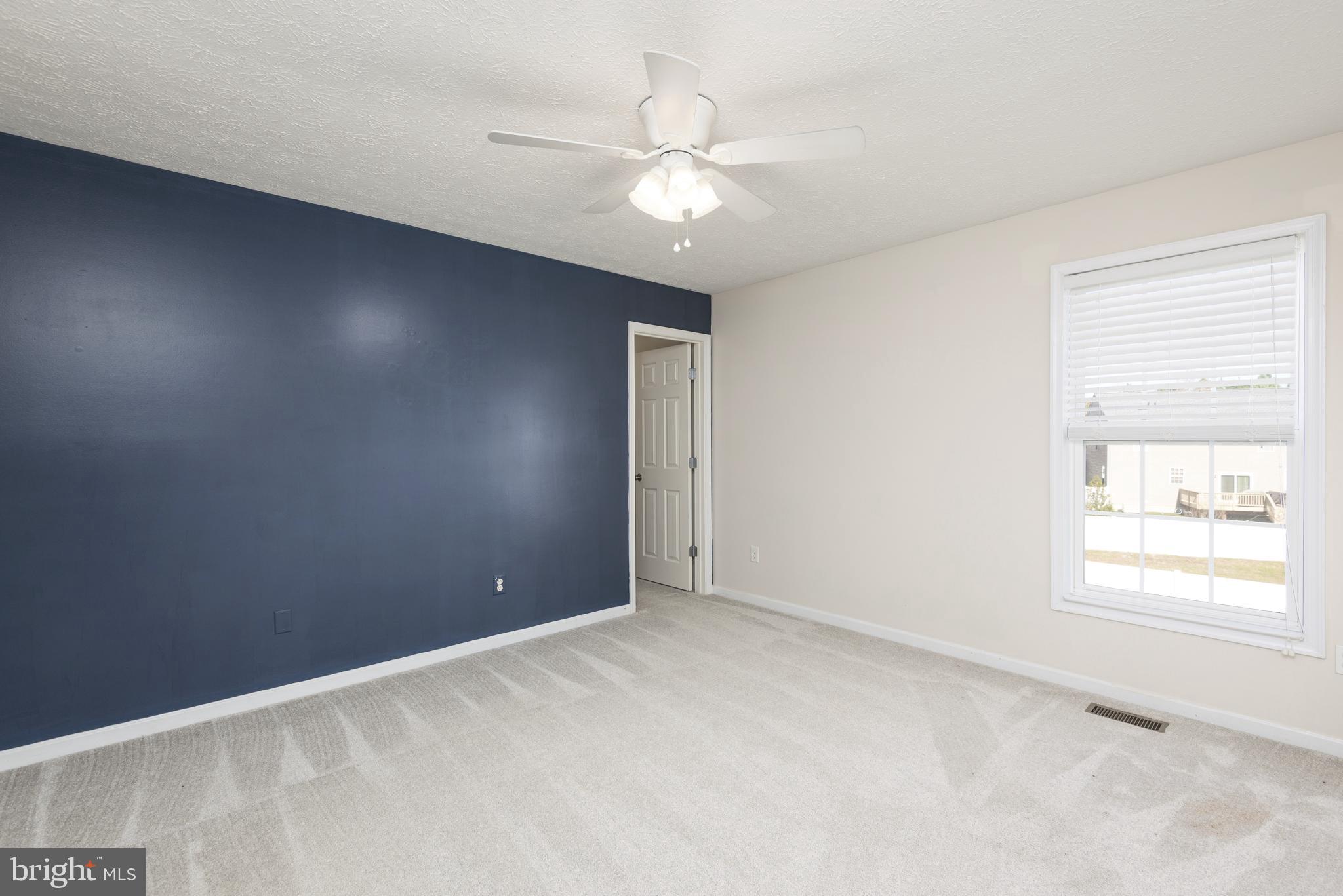 1208 Painted Fern Road Denton, MD 21629 - Photo 23 of 39 an empty room with windows and chandelier fan