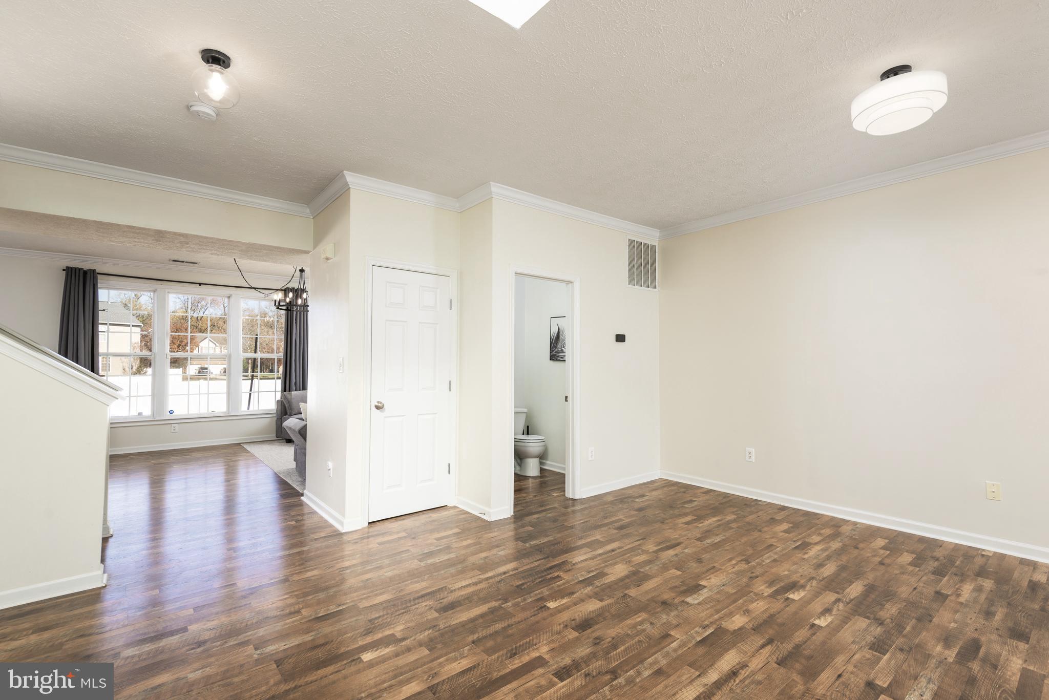 1208 Painted Fern Road Denton, MD 21629 - Photo 4 of 39 a view of empty room with wooden floor and fan