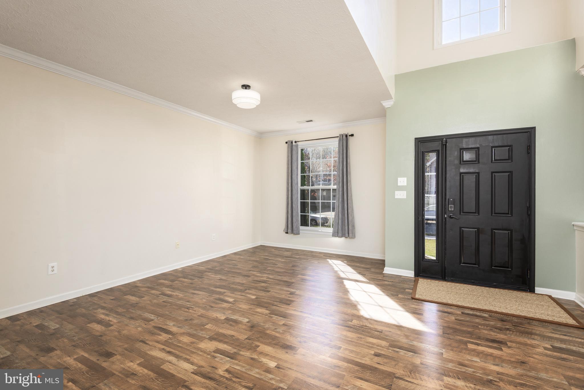 1208 Painted Fern Road Denton, MD 21629 - Photo 5 of 39 a view of an empty room with wooden floor and a window
