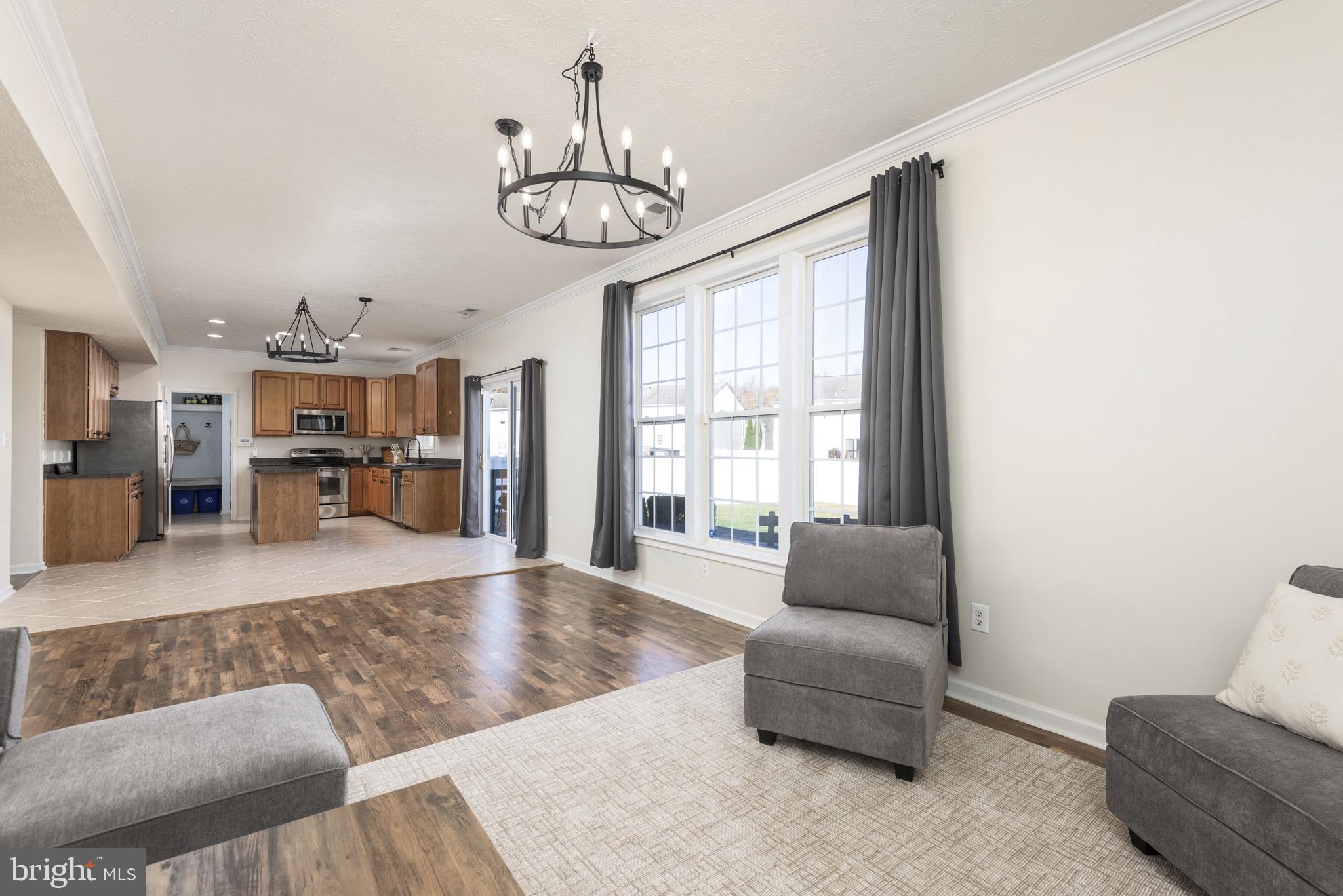 1208 Painted Fern Road Denton, MD 21629 - Photo 10 of 39 a living room with furniture and a chandelier